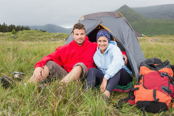 Couple on camping trip smiling at camera