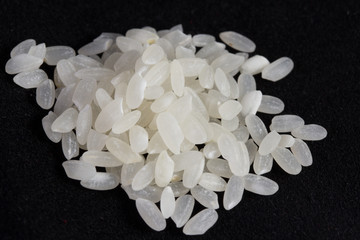 Fototapeta na wymiar Surowy ryż biały na czarnym tle
