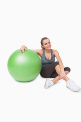 Fototapeta premium Sporty woman sitting next to a fitness ball