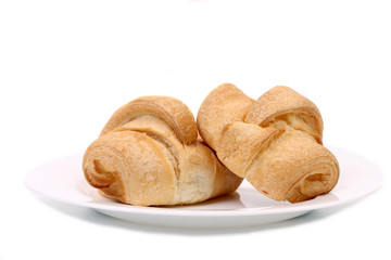Fresh croissants on white plate.