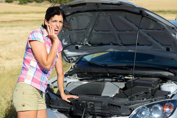 Fototapeta na wymiar Woman checking broken car engine