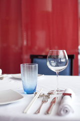 Glasses and plates on table in restaurant - food background