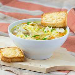 Chicken soup with noodles, carrots and cheese croutons