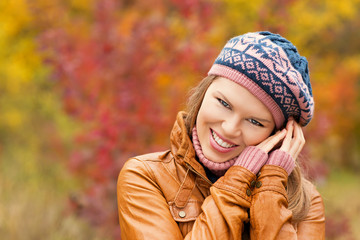 Handsome young woman smiling in park in autumn season.