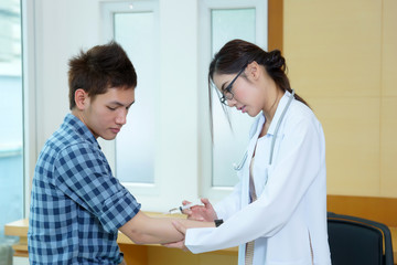 Young woman doctor giving male patient injection