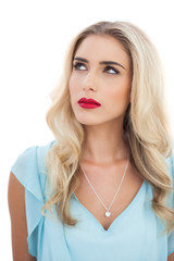 Thoughtful blonde model in blue dress looking away