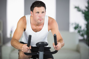 Plakat Attractive fit man exercising on bike