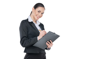Smiling businesswoman writing down something into tablet,