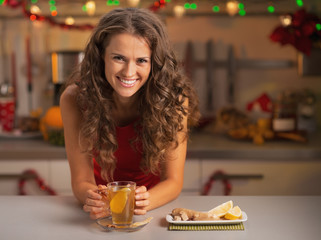 Woman drinking ginger tea in christmas decorated kitchen