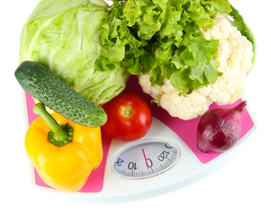 Fresh vegetables on scales on grey background