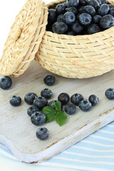 Blueberries in wooden basket on board on napkin