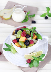 Fruit salad in cup on wooden table