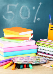 Office supplies on table on school board background