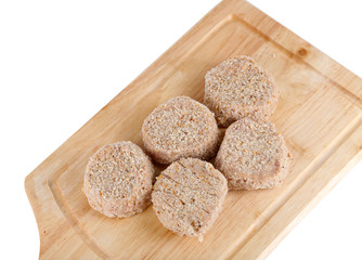 Meat patties on board isolated on white