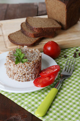 Buckwheat in plate with bread and vegetables closeup