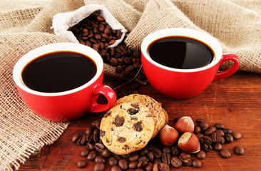 Red cups of strong coffee with coffee beans and cookies