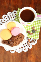 Cocoa in cup with sweets and cocoa powder