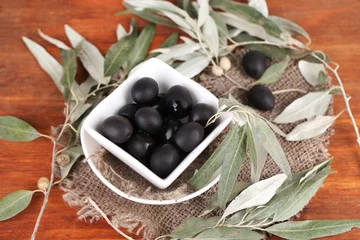 Foto op Plexiglas Olives in bowl with branch on sackcloth on wooden table © Africa Studio