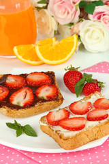 Delicious toast with strawberry on plate close-up