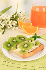 Delicious toast with kiwi on table on light background