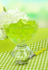 Tasty jelly cubes in bowl on table on light background