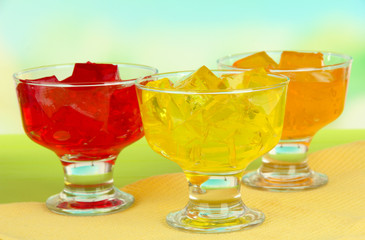 Tasty jelly cubes in bowls on table on light background