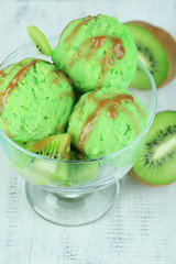 Delicious ice cream on glass vase on wooden table close-up
