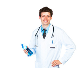 Portrait of a smiling male doctor holding bottle of water on whi