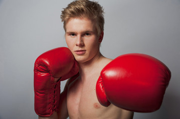 Young blond man with boxing gloves