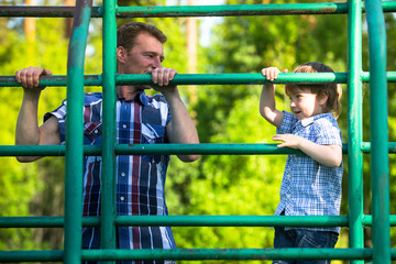 Obraz premium Father and son playing on the park playground.