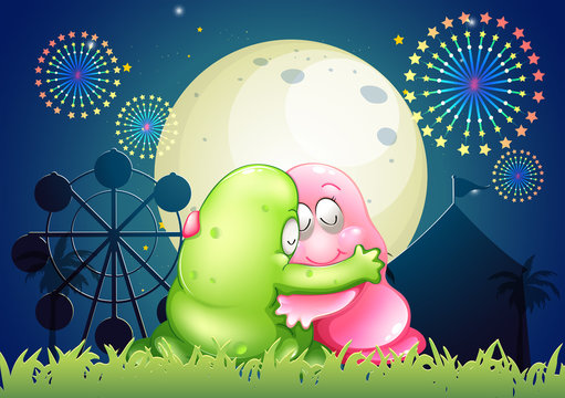 A pink and a green monster hugging each other in front of the am