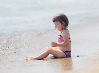 Fototapeta na wymiar girl siting on sand beach