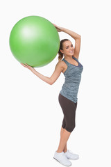 Fototapeta premium Cheerful blonde woman holding a fitness ball