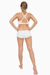 Fototapeta premium Rear view of ponytailed woman stretching her legs