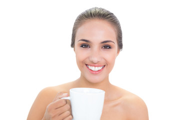 Cheerful young brunette woman holding a mug