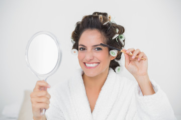 Smiling natural brunette using eyebrow brush