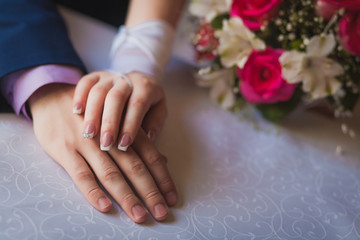 Obraz na płótnie Canvas newlywed's hands and wedding bouquet