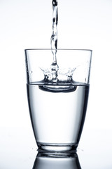falling water touches the surface of the water in the glass