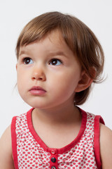 Naklejka premium happy thinking 2-year-old baby looking towards her future