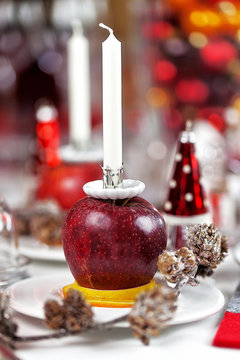 Weihnachtliche Tischdekoration mit Apfel und Kerze