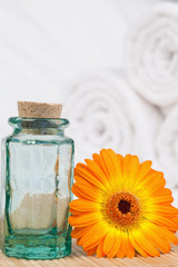 Obraz na płótnie Canvas Sunflower with a glass phial and white towels