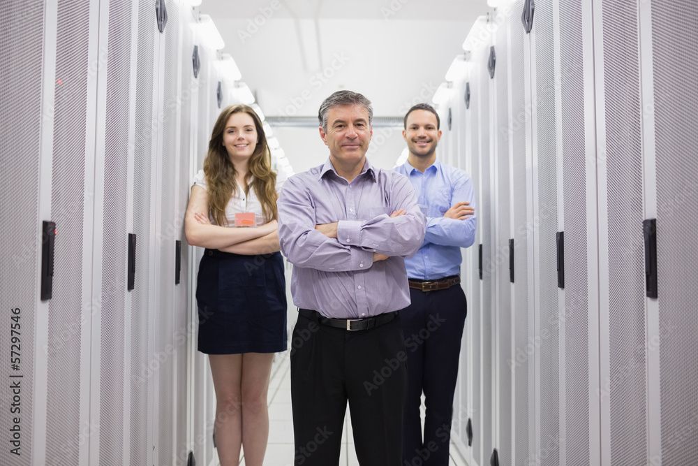 Poster Three smiling technicians standing in data center