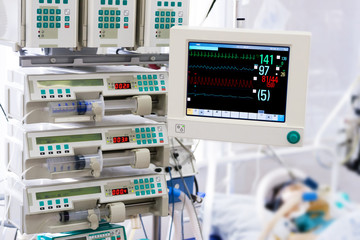 Patient with monitor and infusion pumps in an ICU - 57298911
