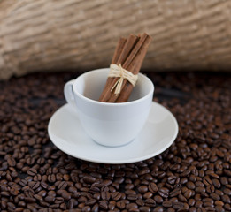 grains de café et bâtons de cannelle dans tasse