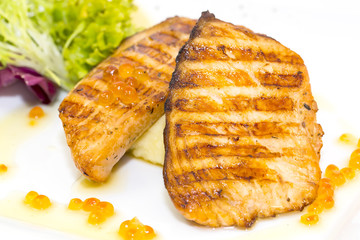 Grilled salmon fillet with vegetables and caviar