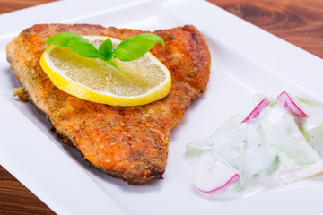 Grilled trout with lemon on the plate