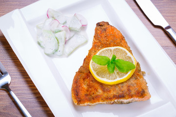 Grilled trout with lemon on the plate