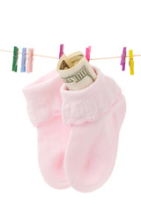 Money in sock on laundry line with pink clothespins,isolate d on