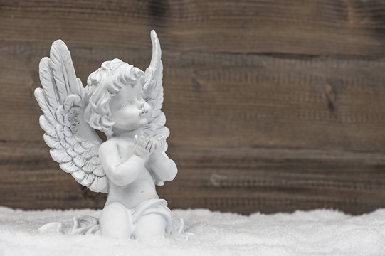 little white angel ion wooden background