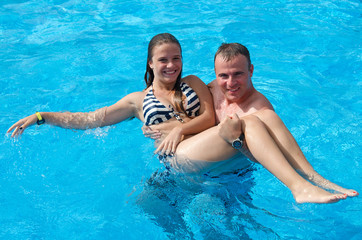 Father and daughter in tropical swimming pool